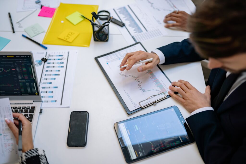 Personne analysant des graphiques de marché sur un bureau